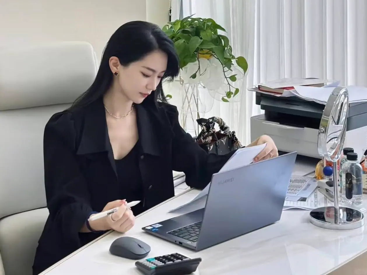 Professional reviewing documents beside a laptop